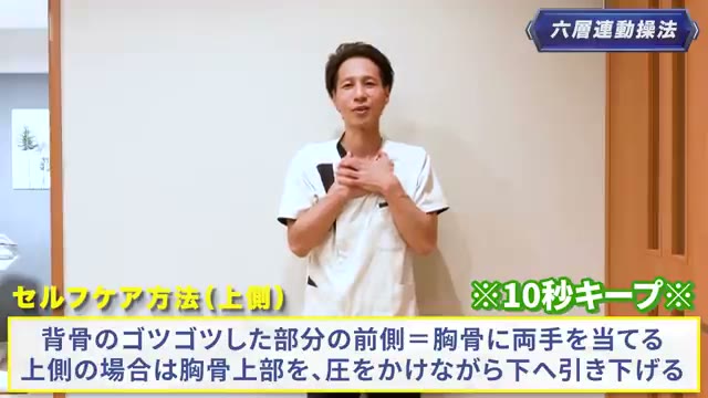 背骨のゴツゴツした部分の前側＝胸骨の上部に両手を当て、圧をかけながら下へ引き下げる・10秒（動画より）