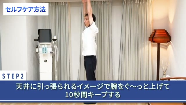 天井に引っ張られるイメージで腕を上げ、10秒キープ(動画より)